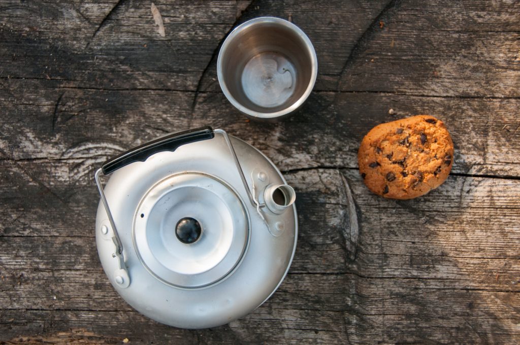 aluminum teapot cup oatmeal cookies wooden table