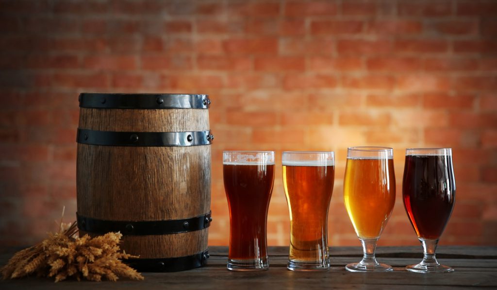 different glasses of beer wooden barrel malted grain