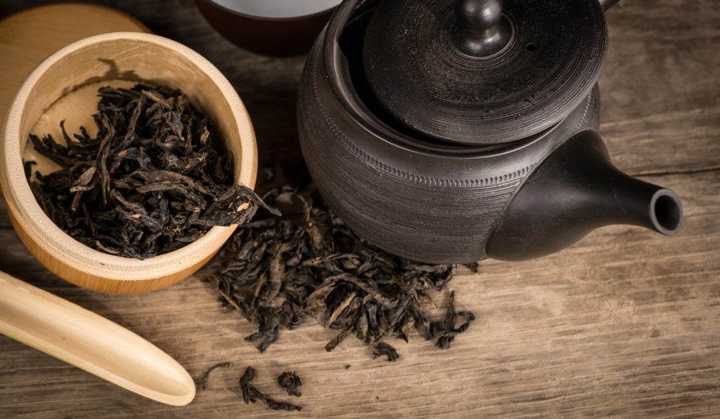 dried black tea black pot  wooden table 