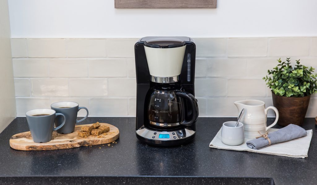 electric drip coffee maker on kitchen cups of coffee