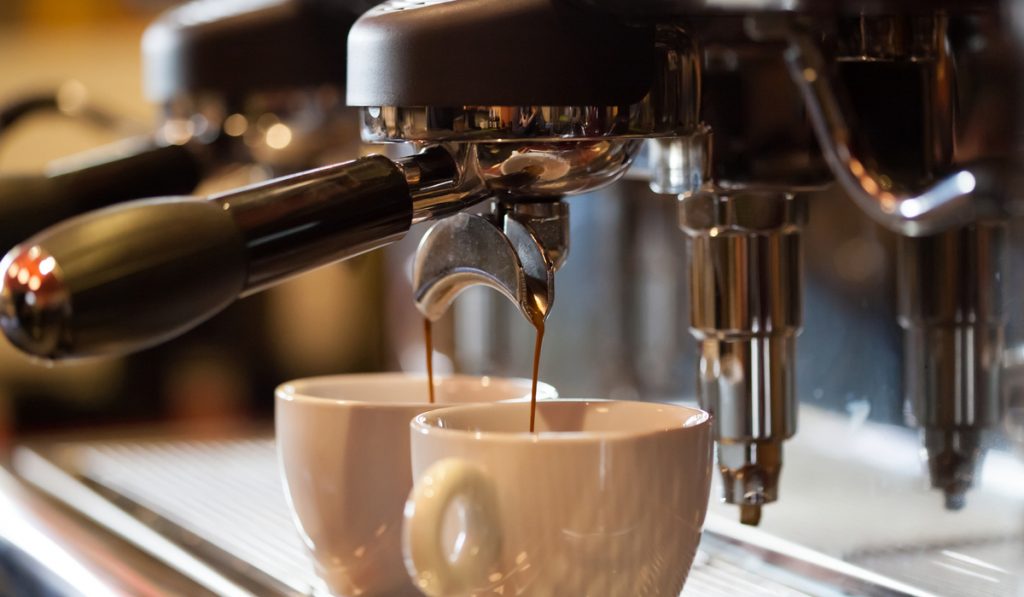 espresso machine pouring coffee two cups 