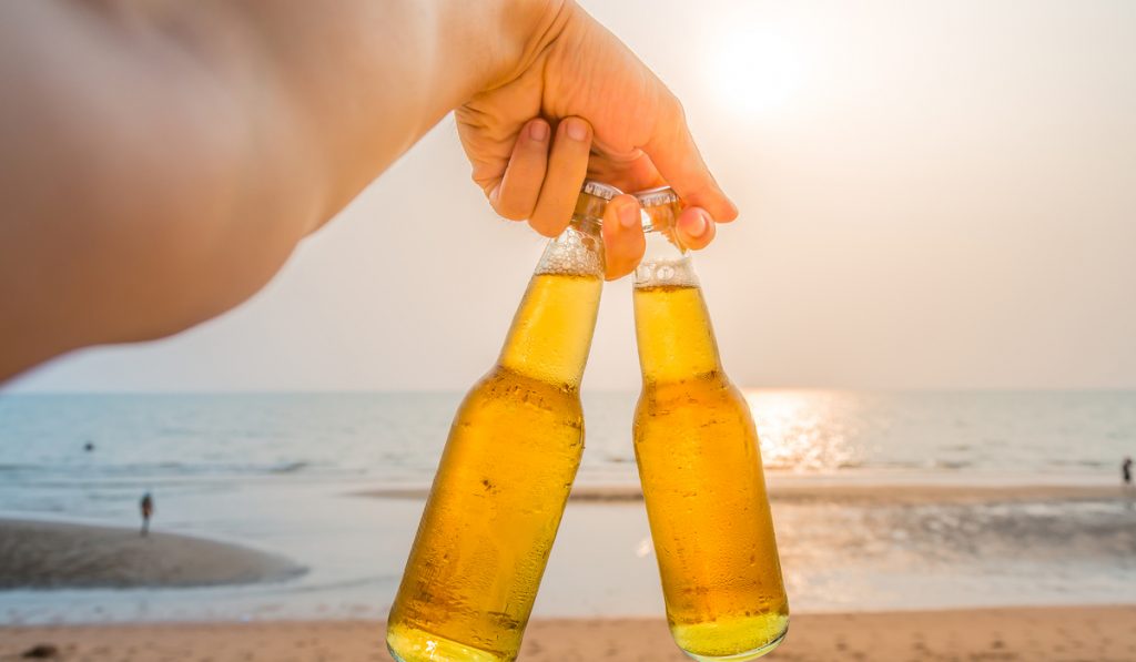 hand carry beer bottles on beach sunset