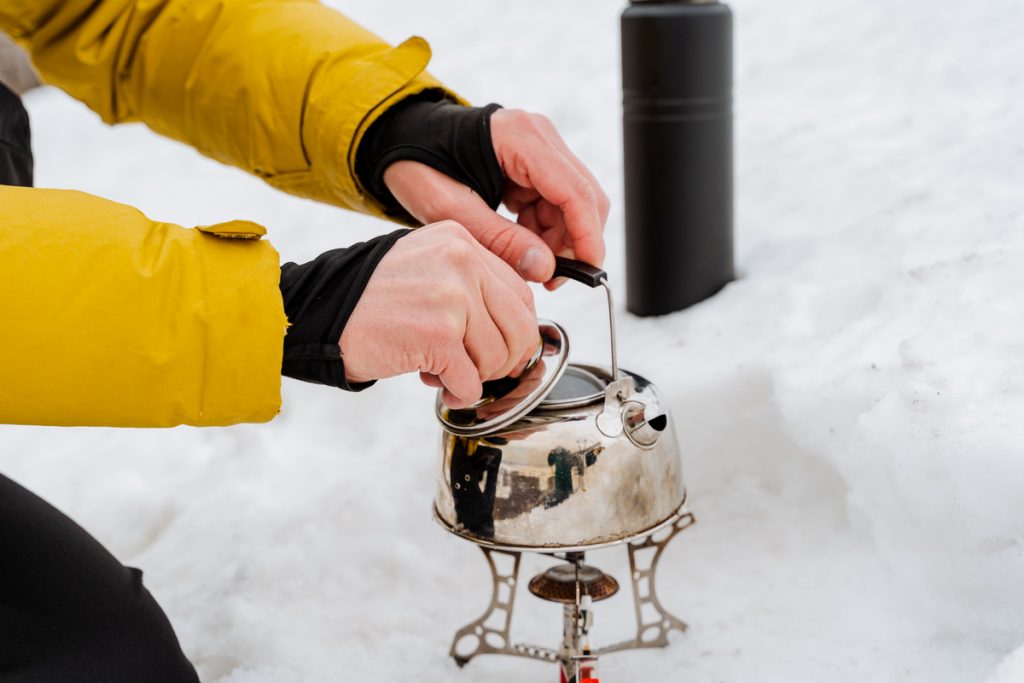 hand holds open lid aluminum kettle 