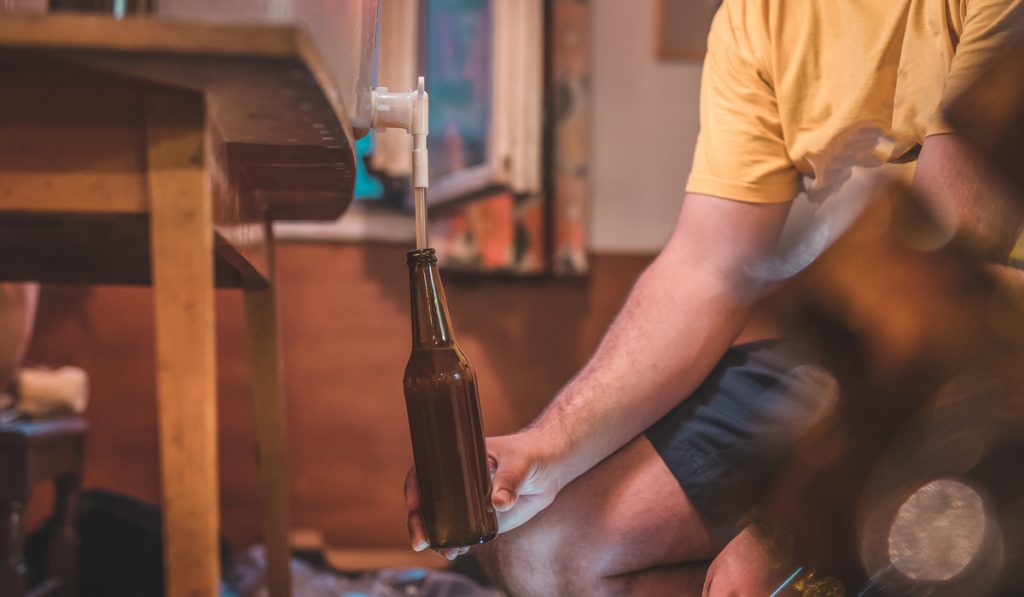 man starting to fill beer bottle final step 